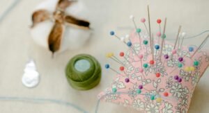 Colorful pins and threads on a sewing workspace, perfect for crafting inspiration.